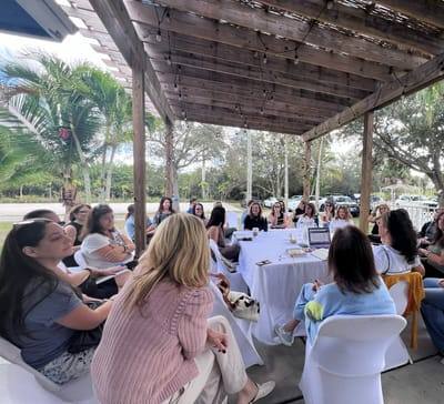 Women gathered around the tables under the pergola