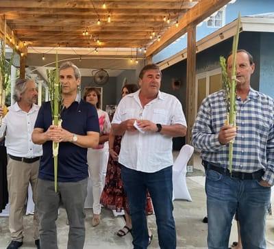 Men holding lulavs under the pergola at Sukkot