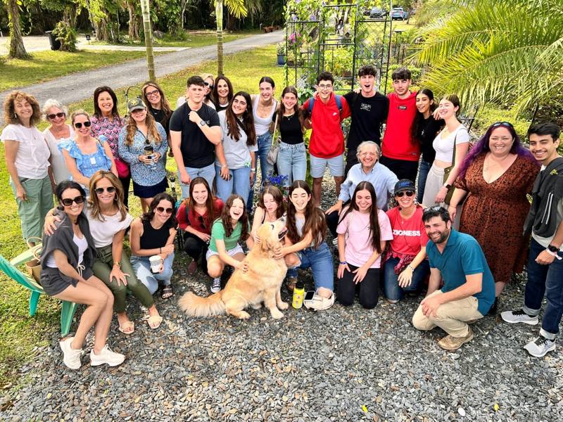 Liumi members of every age, teenagers to grandparents, gathered in the garden with a golden retriever