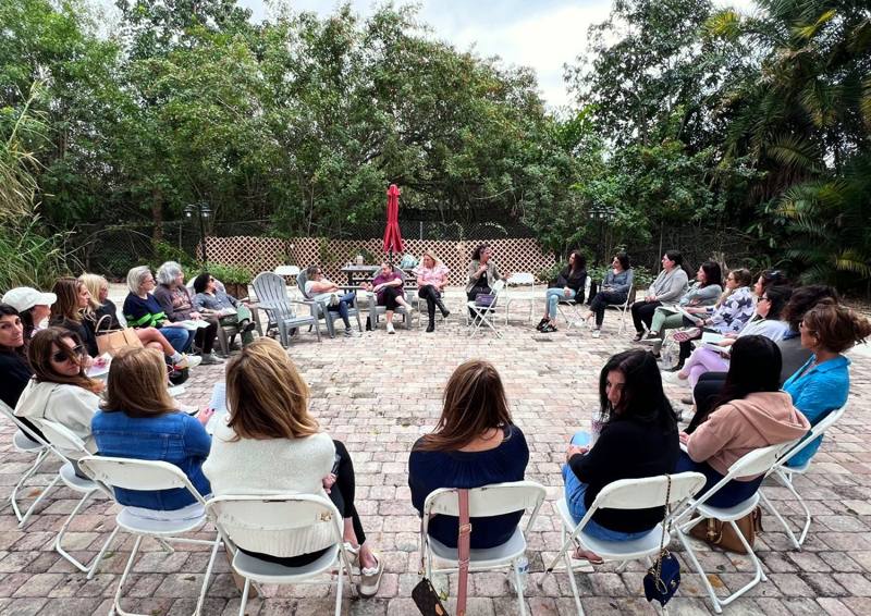 A circle of women in conversation on the paver plaza
